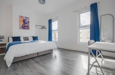a bedroom with a bed and a desk and a mirror at Property is sold in Liverpool