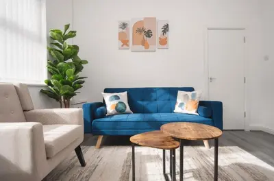 a living room with a blue couch and a table at Property is sold in Liverpool
