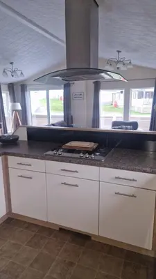 a kitchen with white cabinets and a stove top oven at Coastal Retreat Lodge in Morecambe