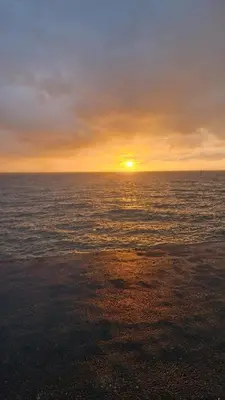 a sunset over the ocean with the sun setting at Coastal Retreat Lodge in Morecambe