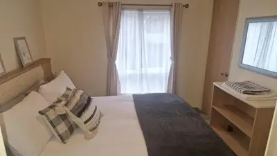 a bedroom with a bed with pillows and a window at Coastal Retreat Lodge in Morecambe