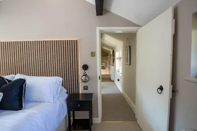 a bedroom with a bed with a table and a hallway at Rainbow Cottage Spacious Detached Home, Hot Tub, Sleeps 7 in Ormskirk