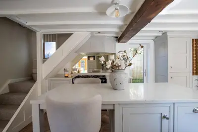 a kitchen with a table with a vase of flowers on it at Rainbow Cottage Spacious Detached Home, Hot Tub, Sleeps 7 in Ormskirk