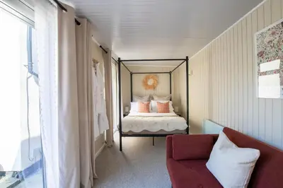 a bedroom with a canopy bed with a red chair at Rainbow Cottage Spacious Detached Home, Hot Tub, Sleeps 7 in Ormskirk