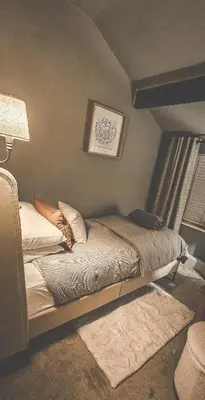 a bedroom with a bed and a lamp and a window at Rainbow Cottage Spacious Detached Home, Hot Tub, Sleeps 7 in Ormskirk