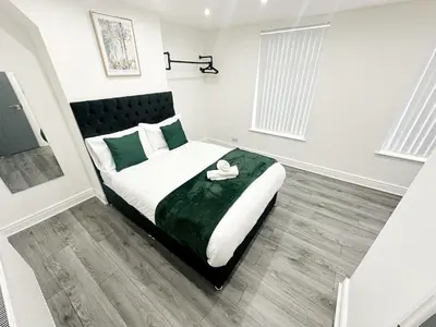 a bedroom with a bed with a swan on it at Spacious Home, Central Liverpool, Sleeps 9, 2 Bathroom, Free Parking in Liverpool