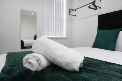 a pile of towels sitting on top of a bed at Spacious Home, Central Liverpool, Sleeps 9, 2 Bathroom, Free Parking in Liverpool