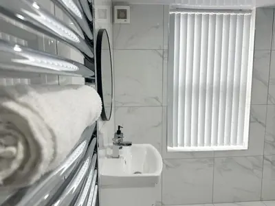 a white bathroom with a sink and a window at Spacious Home, Central Liverpool, Sleeps 9, 2 Bathroom, Free Parking in Liverpool
