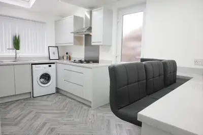a kitchen with white cabinets and a washer and dryer at Spacious Home, Central Liverpool, Sleeps 9, 2 Bathroom, Free Parking in Liverpool