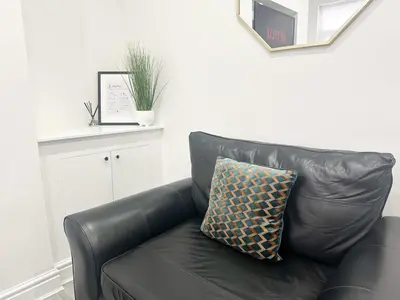 a black leather couch with a pillow on it at Spacious Home, Central Liverpool, Sleeps 9, 2 Bathroom, Free Parking in Liverpool