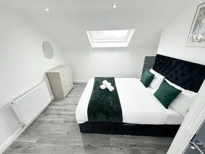 a bedroom with a large bed with green pillows at Spacious Home, Central Liverpool, Sleeps 9, 2 Bathroom, Free Parking in Liverpool