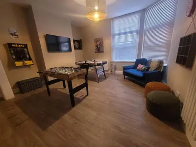 a living room with a table and a blue couch at Tower Suites - HOT TUB sleeps 14 in Blackpool
