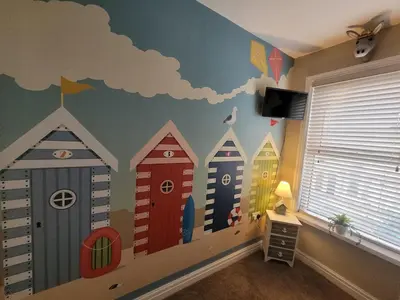 a room with a wall with a mural of houses at Tower Suites - HOT TUB sleeps 14 in Blackpool