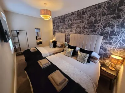 two beds in a hotel room with two lamps at Tower Suites - HOT TUB sleeps 14 in Blackpool