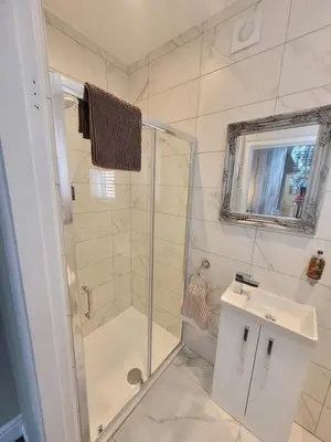 a bathroom with a shower and a toilet and a sink at Tower Suites - HOT TUB sleeps 14 in Blackpool