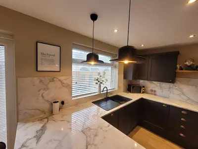 a kitchen with marble counter tops and a sink at Tower Suites - HOT TUB sleeps 14 in Blackpool