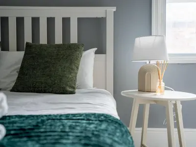 a bed with a green pillow and a table with a lamp at Flat 3, Colquitt St, 1 Bed, L1 - Pass the Keys in Liverpool