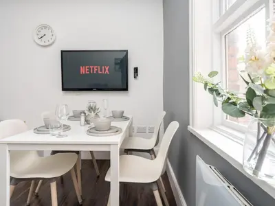 a white dining room table with a tv on a wall at Flat 3, Colquitt St, 1 Bed, L1 - Pass the Keys in Liverpool