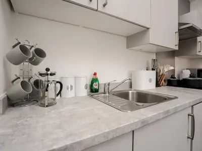 a kitchen counter with a sink and white cabinets at Flat 3, Colquitt St, 1 Bed, L1 - Pass the Keys in Liverpool