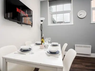 a white dining room table with white chairs and a tv at Flat 1, Colquitt St, 1 Bed, L1 - Pass the Keys in Liverpool