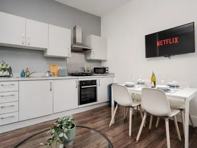 a kitchen with white cabinets and a table and chairs at Flat 1, Colquitt St, 1 Bed, L1 - Pass the Keys in Liverpool