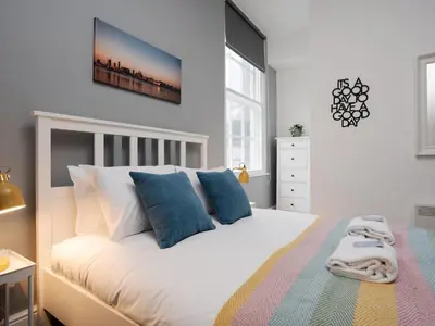 a bedroom with a large white bed with blue pillows at Flat 1, Colquitt St, 1 Bed, L1 - Pass the Keys in Liverpool