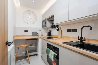 a kitchen with white cabinets and a sink at Private Kitchen & WM Work Desk Free Parking in Liverpool