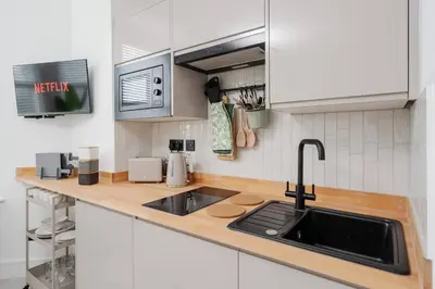 a kitchen with white cabinets and a sink at Private Kitchen & WM Work Desk Free Parking in Liverpool