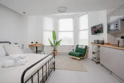 a bedroom with a bed and a green chair at Private Kitchen & WM Work Desk Free Parking in Liverpool