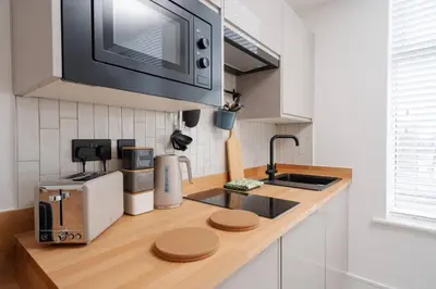 a kitchen with a counter top with a microwave at Cosy Nook Kitchen w Washer & SofaBed Parking in Liverpool