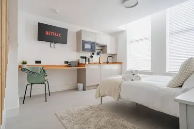 a bedroom with a bed and a kitchen at Cosy Nook Kitchen w Washer & SofaBed Parking in Liverpool
