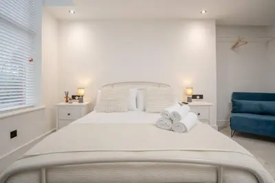 a bedroom with a white bed with towels on it at Cosy Nook Kitchen w Washer & SofaBed Parking in Liverpool
