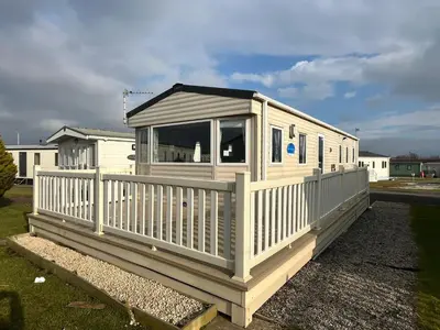 a small white house with a white fence at Seaside Retreat-Sleeps 8-Free Parking in Morecambe