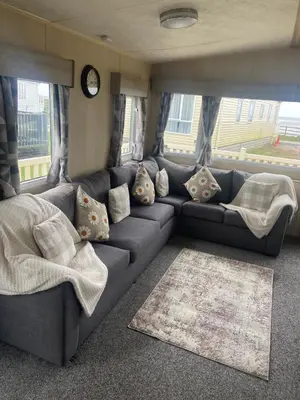 a living room with a blue couch with pillows at Seaside Retreat-Sleeps 8-Free Parking in Morecambe