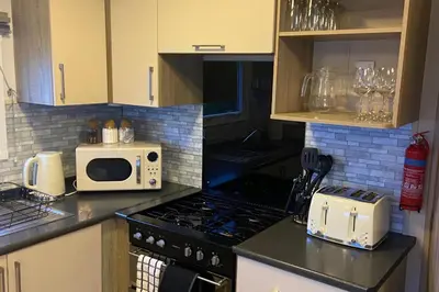 a kitchen with a stove and a microwave at Seaside Retreat-Sleeps 8-Free Parking in Morecambe