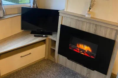 a living room with a fireplace and a television at Seaside Retreat-Sleeps 8-Free Parking in Morecambe