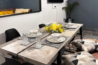 a dining room table with yellow flowers on it at Oak Suite - 2 Bed - Sleeps 4 - Central Blackpool in Blackpool