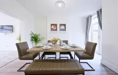 a dining room with a wooden table and chairs at 3 Bed House, Free Parking, Garden in Ince-in-Makerfield