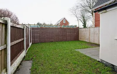 a backyard with a fence and a grass yard at 3 Bed House, Free Parking, Garden in Ince-in-Makerfield