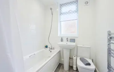 a white bathroom with a sink and a toilet at 3 Bed House, Free Parking, Garden in Ince-in-Makerfield