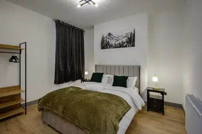 a bedroom with a large bed and a window at 2 Bedroom, 1 Bathroom apartment in Blackpool