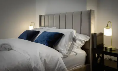 a bedroom with a white bed with blue pillows at 2 Bedroom, 1 Bathroom apartment in Blackpool