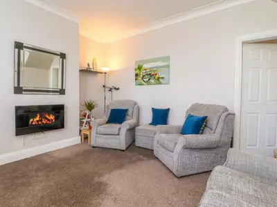 a living room with two chairs and a fireplace at Lytham House in Lytham St Annes
