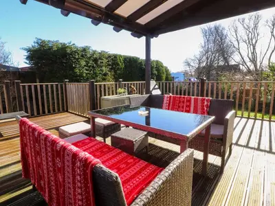 a patio with a table and chairs on a deck at Lytham House in Lytham St Annes