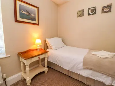 a bedroom with a bed and a table with a lamp at Lytham House in Lytham St Annes