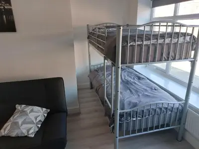 a bunk bed room with two bunk beds and a couch at Anfieldstadiumroomz in Liverpool