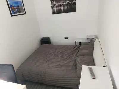 a bedroom with a bed and a remote control at Anfieldstadiumroomz in Liverpool