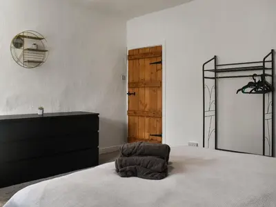 a bedroom with a bed with a dresser and a mirror at Nelson House in Clitheroe