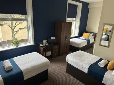 a hotel room with two beds and a mirror at The New Brighton Hotel in New Brighton