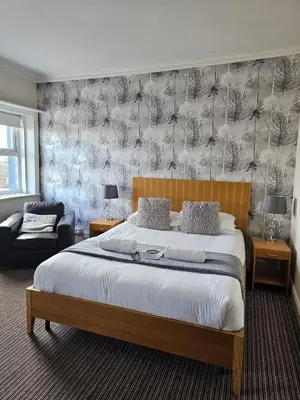 a bedroom with a king sized bed and a couch at The New Brighton Hotel in New Brighton